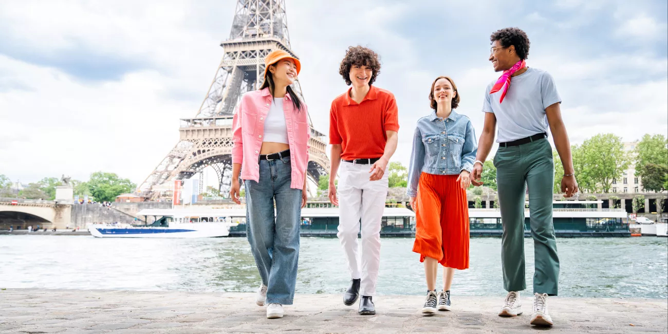 Group of young friends bonding outdoors and having fun sightseeing Paris and Eiffel Tower