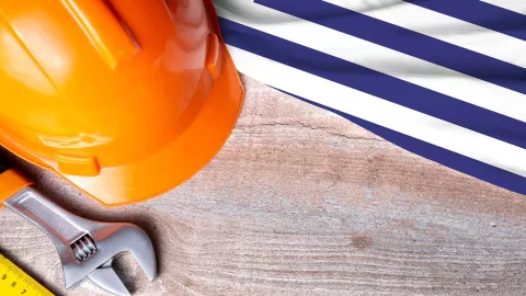 Greece flag and some construction tools on wooden background
