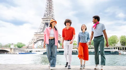 Group of young friends bonding outdoors and having fun sightseeing Paris and Eiffel Tower