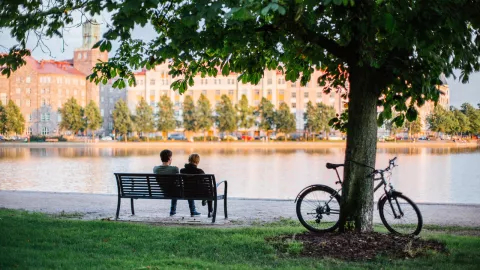 People sitting on the bench by the river